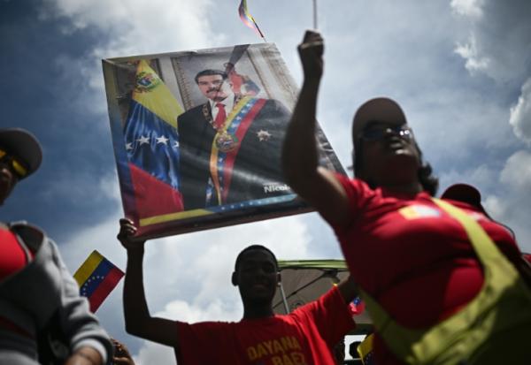 Un homme tient un portrait du président vénézuélien Nicolas Maduro, le 23 septembre 2025 à Caracas