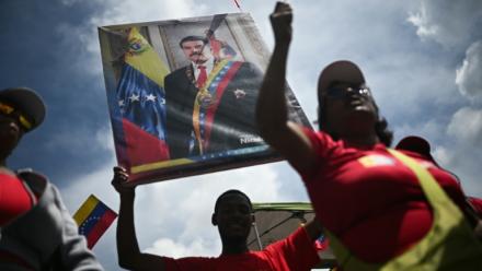 Un homme tient un portrait du président vénézuélien Nicolas Maduro, le 23 septembre 2025 à Caracas