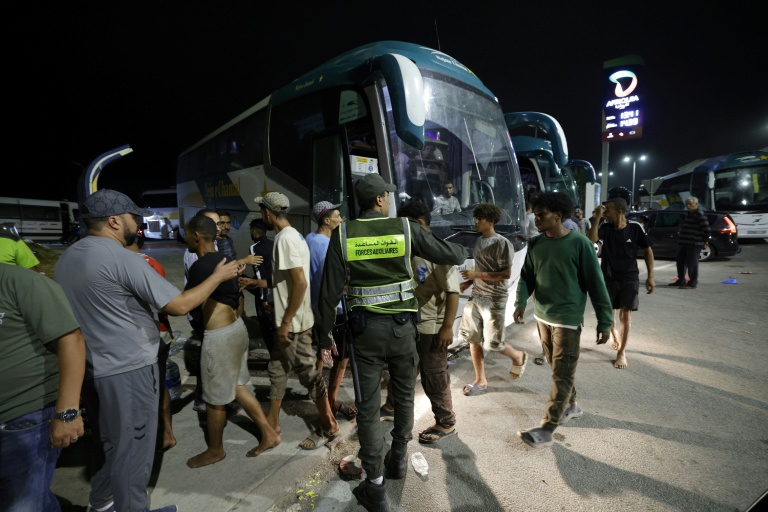 Des membres des forces de l'ordre marocaines acheminent par bus vers leurs villes d'origine des personnes qui avaient pénétré illégalement dans l'enclave espagnole de Ceuta, sur la côte nord du Maroc, le 1er août 2026 à Fnideq 