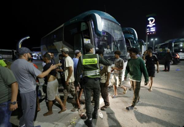 Des membres des forces de l'ordre marocaines acheminent par bus vers leurs villes d'origine des personnes qui avaient pénétré illégalement dans l'enclave espagnole de Ceuta, sur la côte nord du Maroc, le 1er août 2026 à Fnideq 