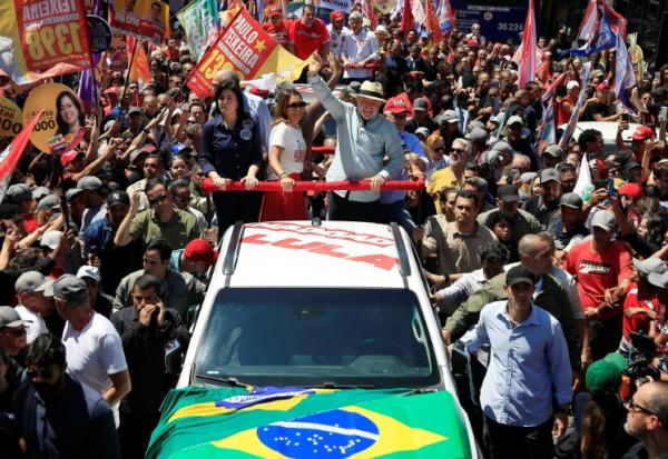 Le président brésilien Luiz Inacio Lula da Silva, candidat à sa réélection, tient le drapeau national durant un meeting à Sao Paulo, au Brésil, le 26 septembre 2026