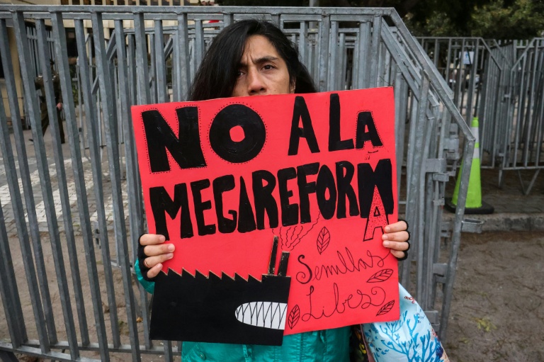 Une personne manifeste devant le Congrès national à Valparaiso au Chili pendant le débat au Sénat sur un projet de réforme économique, le 15 juillet 2026