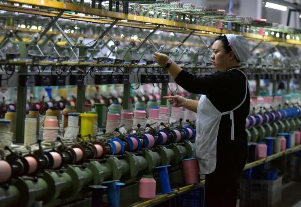 Une ouvrière sur une chaîne de production de soie à Fuyang, dans la province de l'Anhui, dans l'est de la Chine, le 20 octobre 2025