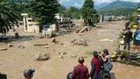 Des habitants observent des maisons partiellement submergées dans des eaux boueuses à la suite d'inondations soudaines survenues à Trishuli Bazar, dans le district de Nuwakot au Népal, le 26 août 2026.