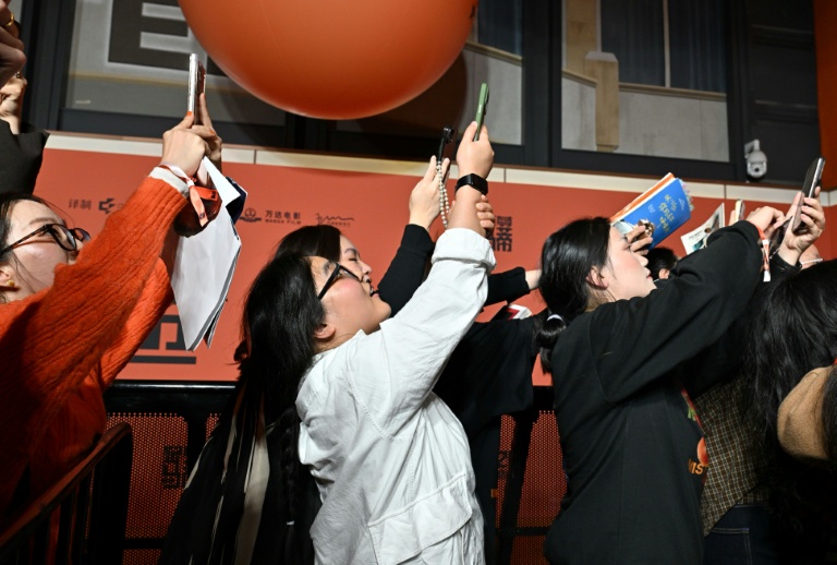 Des fans chinois se rassemblent à l'arrivée de l'acteur franco-américain Timothée Chalamet (non visible) sur le tapis rouge pour la projection de son film Marty Supreme à Pékin le 10 mars 2026