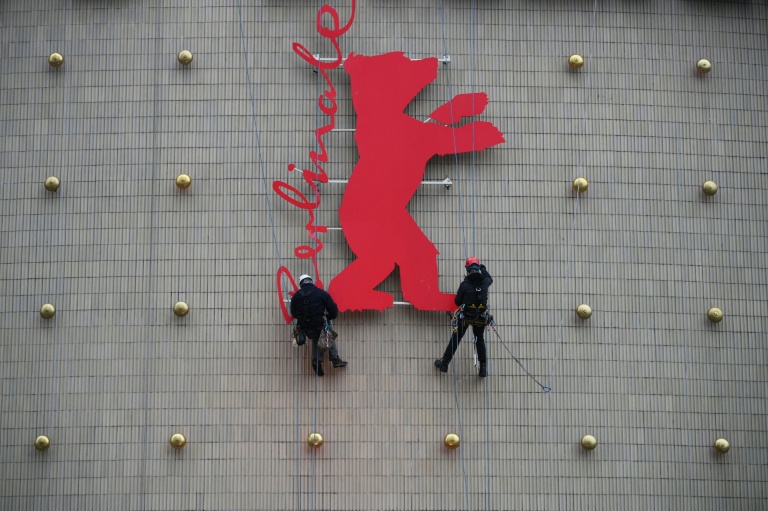 Des escaladeurs industriels fixent un Ours de la Berlinale sur la façade du cinéma Zoo Palast à Berlin, le 10 février 2026