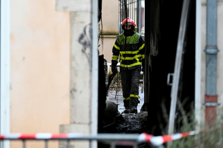 Un pompier dans le bâtiment où s'est déclaré dans la nuit un incendie mortel à Neuves-Maisons, en Meurthe-et-Moselle, le 30 novembre 2025 