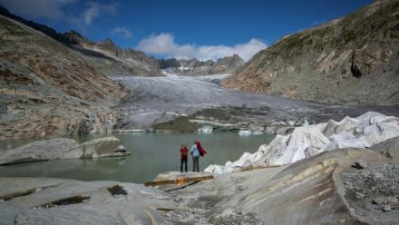 Des touristes devant le glacier du Rhône près de Gletsch, dans les Alpes suisses, le 12 septembre 2025