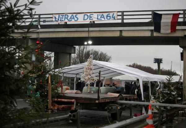 Des sapins de Noël installés sur un barrage de l'A64 par les agriculteurs en colère, le 22 décembre 2025 à Carbonne, en Haute-Garonne 