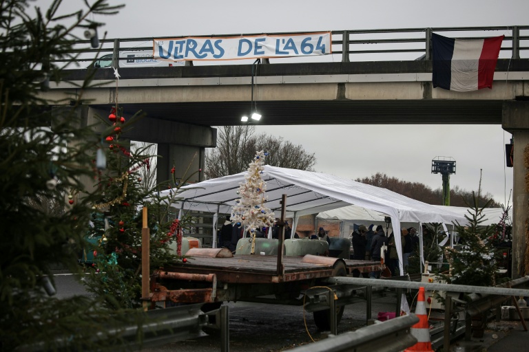 Sur le barrage de l'A64 à Carbonne (Haute-Garonne), des sapins ont été installés à côtés des barnums par les agriculteurs en colère, le 22 décembre 2025