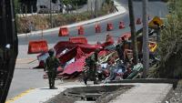 Des soldats se tiennent près des restes d'un péage en construction détruit par une explosion à Santander de Quilichao, en Colombie, le 8 août 2026
