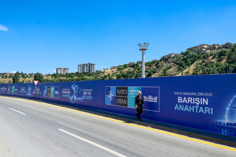 Un habitant passe devant des panneaux d'affichage portant les slogans 