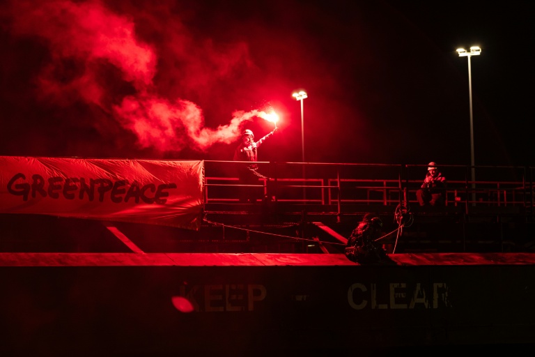 Un militant de Greenpeace lors d'une action pour dénoncer le commerce d'uranium entre la Russie et la France le 2 mars 2026 dans le port de Dunkerque