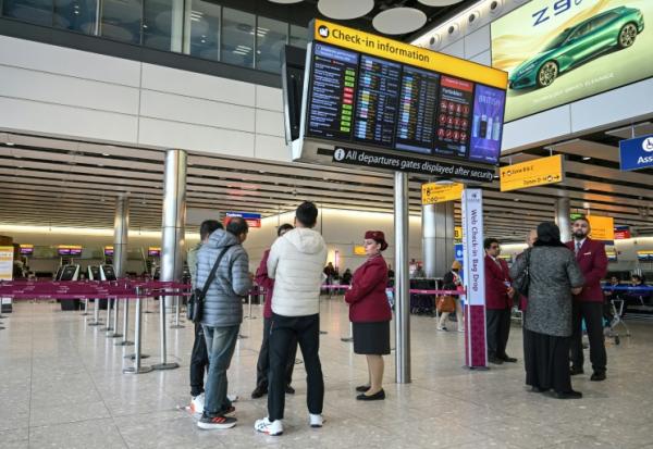 Des passagers devant le comptoir d'enregistrement fermé de la compagnie aérienne Qatar Airways, le 1er mars 2026 à l'aéroport Heathrow de Londres 
