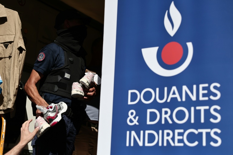 Un agent des douanes inspecte des produits contrefaits avant leur destruction à Marseille, dans le sud-est de la France, le 18 juin 2026