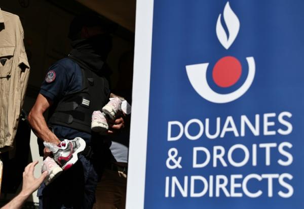 Un agent des douanes inspecte des produits contrefaits avant leur destruction à Marseille, dans le sud-est de la France, le 18 juin 2026