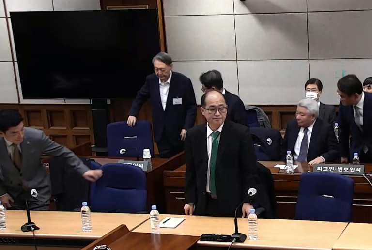 Cette capture d'écran tirée d'une vidéo distribuée par le tribunal central de Séoul et diffusée par l'agence Yonhap montre l'ancien président sud-coréen Yoon Suk Yeol (2e rangée, à gauche) assistant à un procès pour insurrection au tribunal central de Séoul, le 19 février 2026