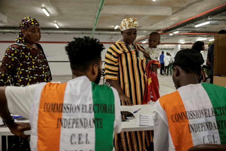 Des représentants de la commission électorale supervisent les opérations de vote pour la présidentielle ivoirienne, à Abidjan le 25 octobre 2025
