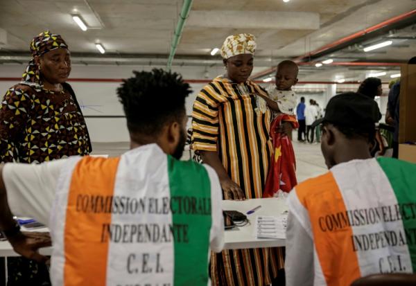 Des représentants de la commission électorale supervisent les opérations de vote pour la présidentielle ivoirienne, à Abidjan le 25 octobre 2025