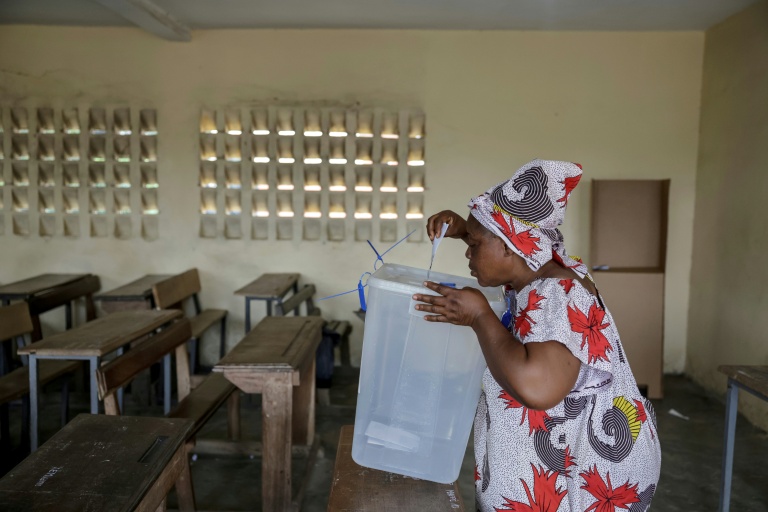 Une femme dépose son bulletin dans l'urne lors de la présidentielle ivoirienne, le 25 octobre 2025 à Abidjan 
