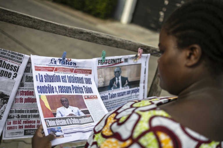 Une habitante regarde les journaux sur un étal dans une rue de Cotonou après une tentative déjouée de coup d'Etat au Bénin, le 8 décembre 2025