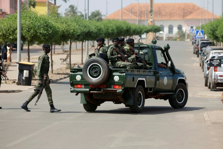 Des soldats armés patrouillent dans une rue près du palais présidentiel à Bissau, le 26 novembre 2025 en Guinée-Bissau