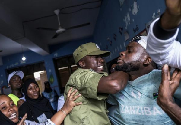 Un policier tanzanien arrête un homme accusé par des responsables électoraux d'avoir tenté de frauder dans un bureau de vote de Stone Town (Tanzanie), le 29 octobre 2025