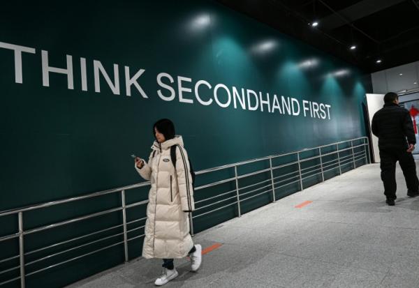 Des passants devant un magasin de seconde main à Shangaï, en Chine, le 10 février 2026