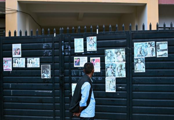 Un homme regarde les photos de personnes mortes ou portées disparues dans la crue destructrice qui a fait plus de 600 morts à la frontière entre le Népal et la Chine, le 29 août 2026 à Katmandou