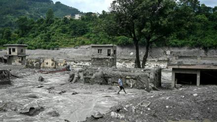 Un homme marche au milieu des décombres après la crue destructrice dans l'Himalaya, le 30 août 2026 à Trishuli, dans le district népalais de Nuwakot 