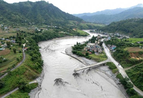 Un pont en partie détruit au-dessus de la rivière Trishuli après la crue destructrice dans l'Himalaya, le 30 août 2026 dans le district népalais de Dhading