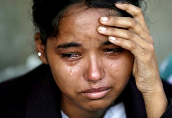 Une femme pleure après avoir été secourue dans un camp militaire à la suite des crues soudaines, dans la ville de Battar Bazar, district de Nuwakot au Népal, le 28 août 2026