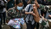 Une militaire porte un enfant secouru après la crue destructrice qui a fait au moins 633 morts à la frontière entre le Népal et la Chine, le 29 août 2026 au camp de Trishuli, dans le district népalais de Nuwakot  