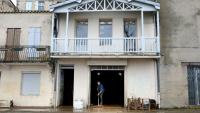 Un habitant nettoie la boue amassé sur le sol d'une maison lors des inondations à La Réole, près de Bordeaux, le 23 février 2026