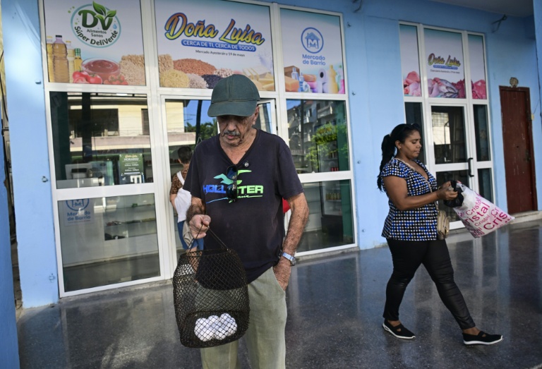 Des personnes sortent avec leurs courses d'un marché de quartier