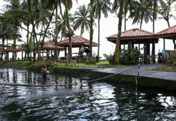 Un touriste dans la piscine de l'hôtel Seme Beach, à Limbé, le 4 octobre 2025 au Cameroun