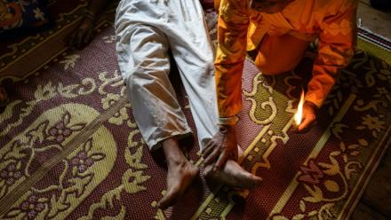 Photo fournie par Luke Duggleby, prise le 10 décembre 2025 et transmise à l'AFP le 25 février 2026, montrant le chef religieux Jaha Satae (c,d), procédant à une cérémonie de purification sur Jawa Jabo (chemise noire), dans le village de Mae Haeng, à Chiang Mai, en Thaïlande