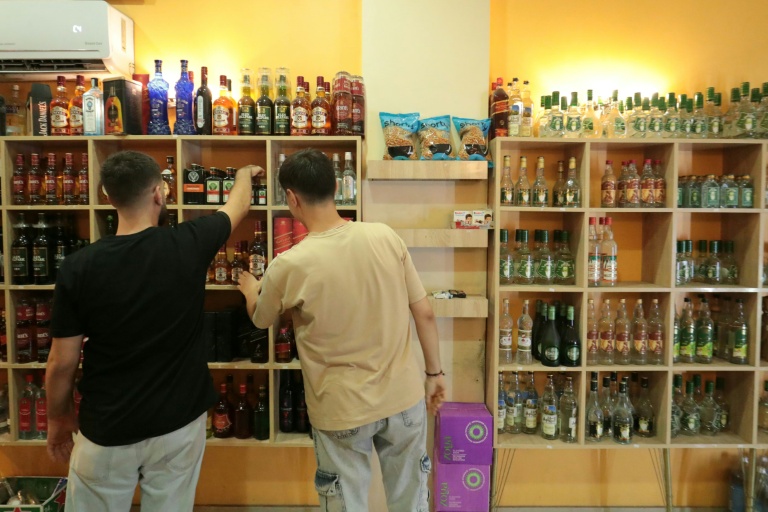 Des clients regardent des bouteilles d'alcool en vente dans un magasin de Qamichli, ville kurde du nord-est de la Syrie, le 18 août 2026