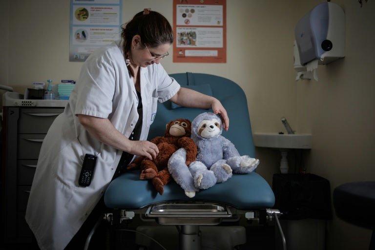 Céline Cazaux, infirmière, dispose des peluches sur une table d'examens gynécologiques de l'unité d'accueil pour enfants en Danger (Uaped) installée dans le centre hospitalier sud francilien (CHSF) à Corbeil-Essonnes, près de Paris, le 30 juin 2026
