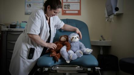 Céline Cazaux, infirmière, dispose des peluches sur une table d'examens gynécologiques de l'unité d'accueil pour enfants en Danger (Uaped) installée dans le centre hospitalier sud francilien (CHSF) à Corbeil-Essonnes, près de Paris, le 30 juin 2026