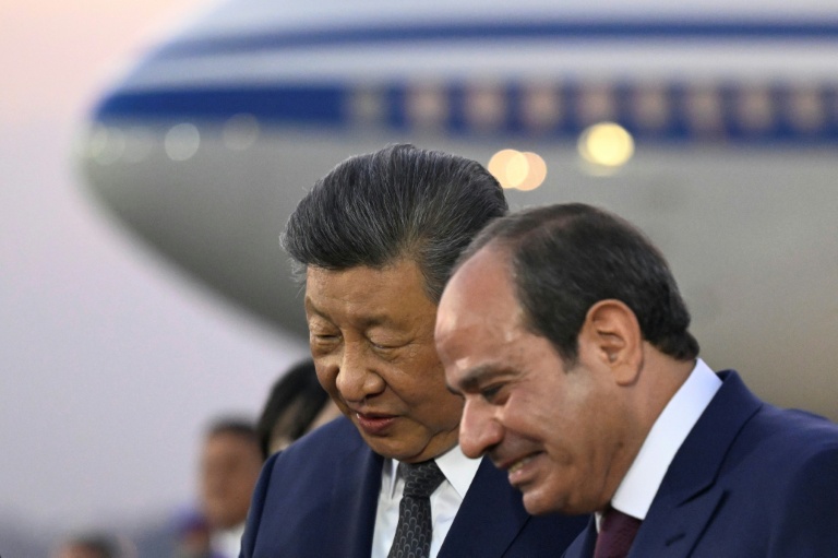 Le président chinois Xi Jinping (g) écoute son homologue égyptien Abdel Fattah al-Sissi à son arrivée sur le tarmac de l'aéroport international du Caire, le 1er septembre 2026