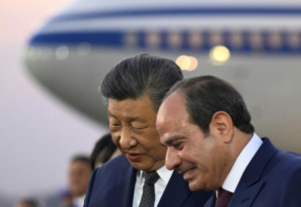 Le président chinois Xi Jinping (g) écoute son homologue égyptien Abdel Fattah al-Sissi à son arrivée sur le tarmac de l'aéroport international du Caire, le 1er septembre 2026