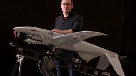 Le directeur général d'Ukrspecsystems, Rory Chamberlain, à côté d'un des drones de reconnaissance Shark dans l'usine britannique de l'entreprise près de Cambridge, dans l'est de l'Angleterre, le 5 mars 2026