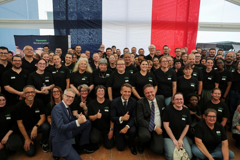 Le président français Emmanuel Macron pose avec les employers de l'usine Vorwerk, qui produit les appareils Thermomix, dans le cadre des 