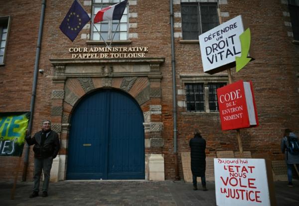 Un homme brandit une pancarte lors d’une manifestation contre le projet d’autoroute A69, devant la cour administrative d’appel à Toulouse, le 11 décembre 2025