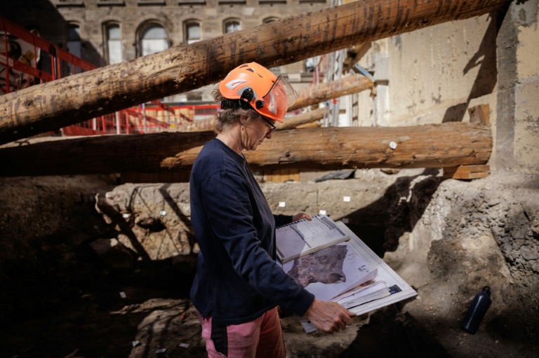Une archéologue de la Ville de Paris examine le plan du site archéologique où un mur de Lutèce datant de l'époque gallo-romaine, a été découvert sous l'Hôtel-Dieu, dans le centre de Paris, le 23 septembre 2026