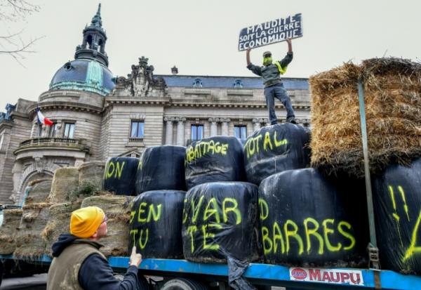 "Maudite soit la guerre économique" peut-on lire sur une pancarte lors d'une manifestation d'agriculteurs devant la préfecture de la Haute-Vienne, à Limoges, le 17 décembre 2025