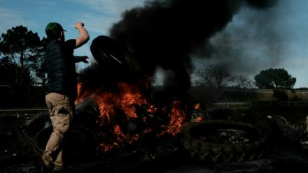 Le 16 décembre 2025, un agriculteur français jette un pneu sur un bûcher installé sur l'autoroute A63, bloquée dans les deux sens à l'échangeur de Cestas, en Gironde