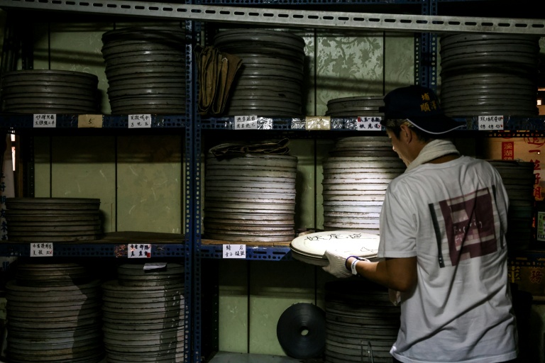 Un employé de l'Institut taïwanais du cinéma et de l'audiovisuel (TFAI) sélectionne la bobine d'un vieux film taïwanais à restaurer, le 29 mai 2026 à Changhua, dans la province de Taïwan
