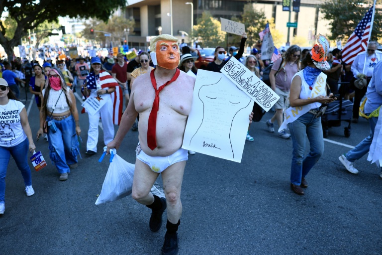 Un manifestant vêtu d'un costume se moquant du président américain Donald Trump participe à la journée nationale de manifestations